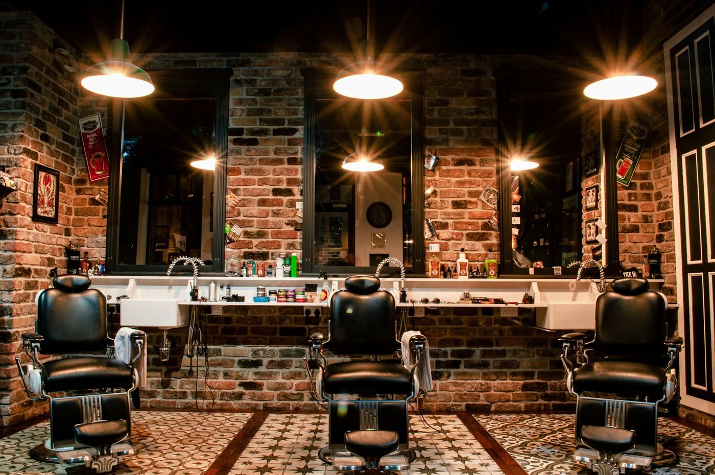 A leather barber chair against a brick wall inside the shop