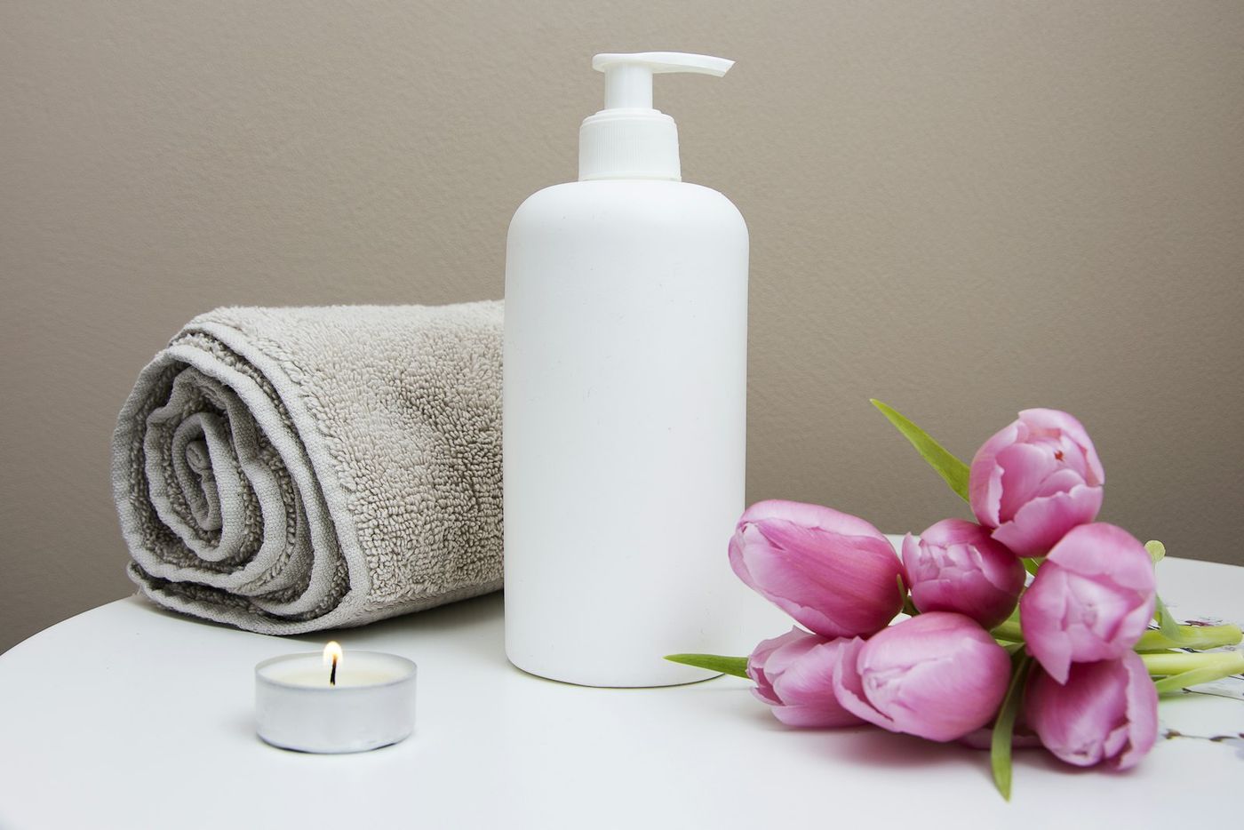 Pump bottle, tulips and a folded towel