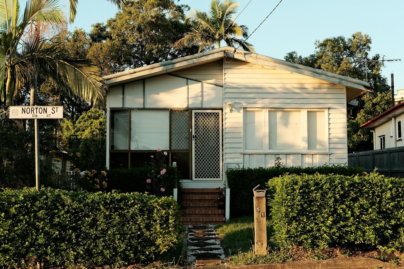 A small white house beside a garden