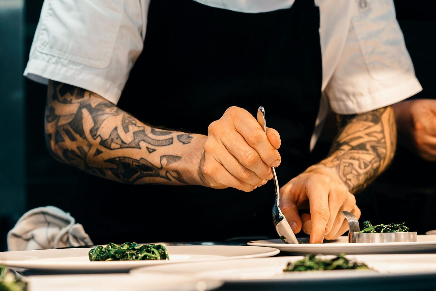 A chef plating a dish at the pass